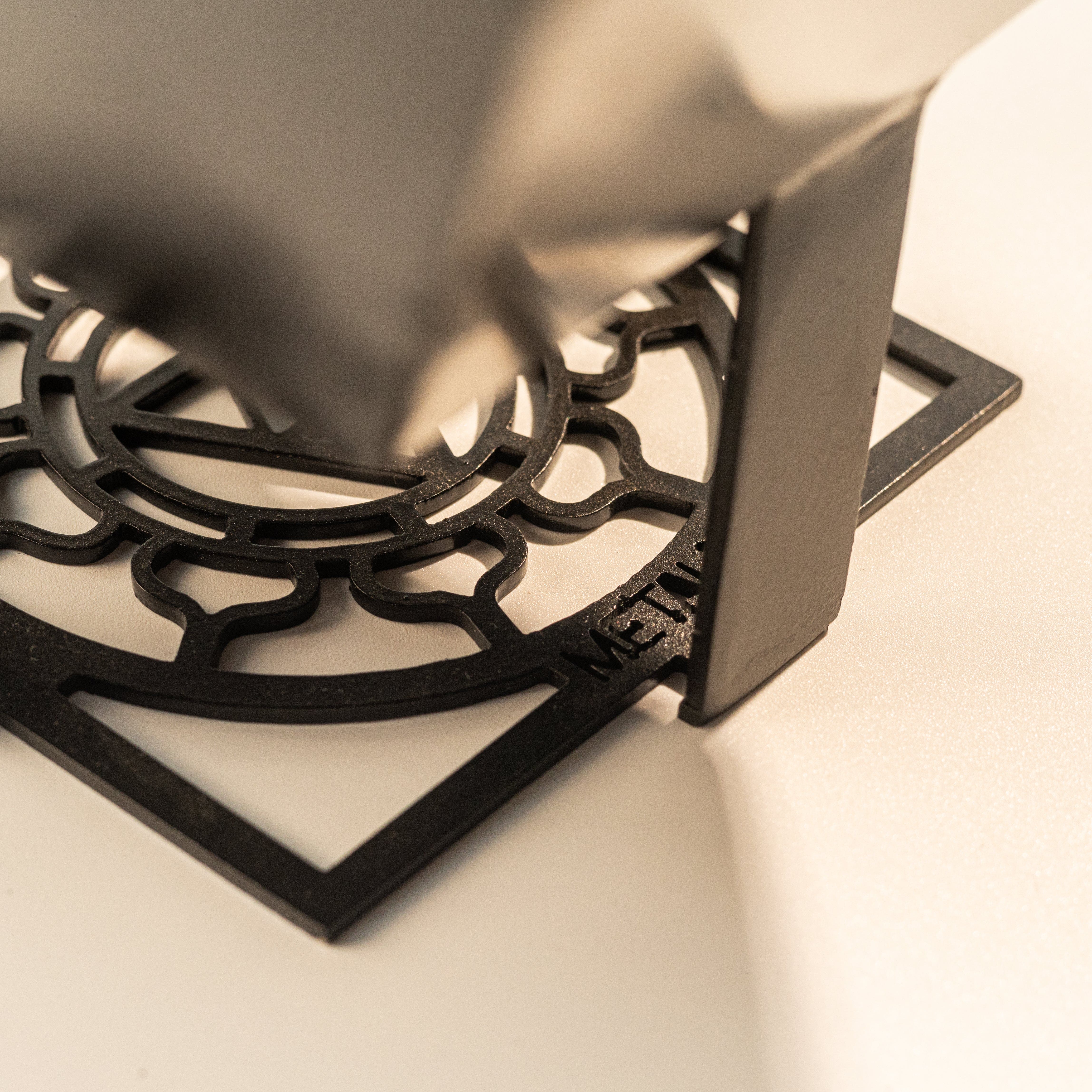 Black metal trivet with intricate design on base of shree yantra - auspicious hindu energy