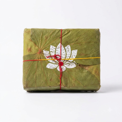 A square Navratri package wrapped in dried leaf box, tied with auspicious Mauli and featuring a white lotus flower illustration on the front with 6 boxes inside.
